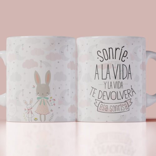 Taza blanca con ilustración de conejitos y frase motivadora “Sonríe a la vida y la vida te devolverá esa sonrisa”, ideal como regalo original con mensaje positivo.