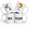 Set de dos tazas blancas con frase “You’re My Person” inspirada en Grey’s Anatomy, con ilustración estilo médico, ideal como regalo especial para pareja o mejor amiga.
